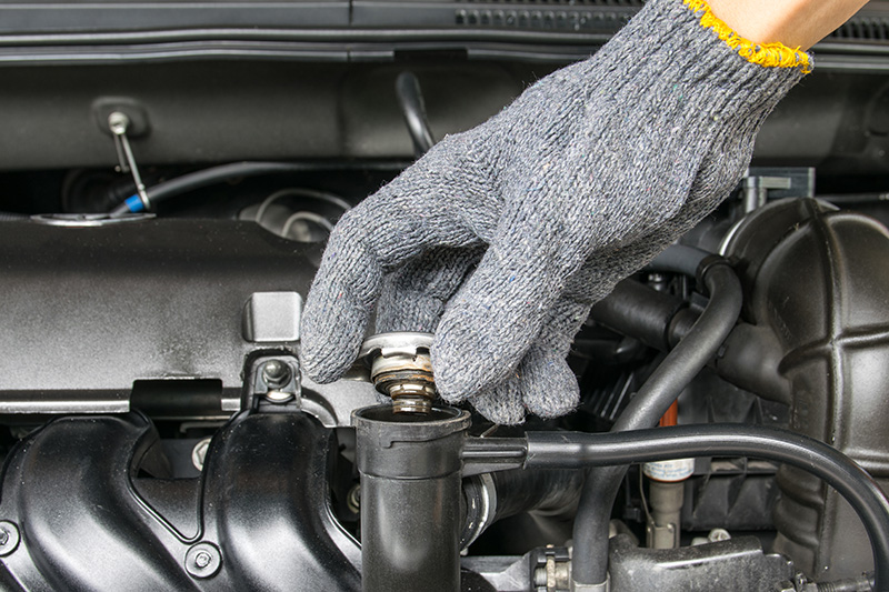 hand opening the valve cover on the engine while performing rv inspection