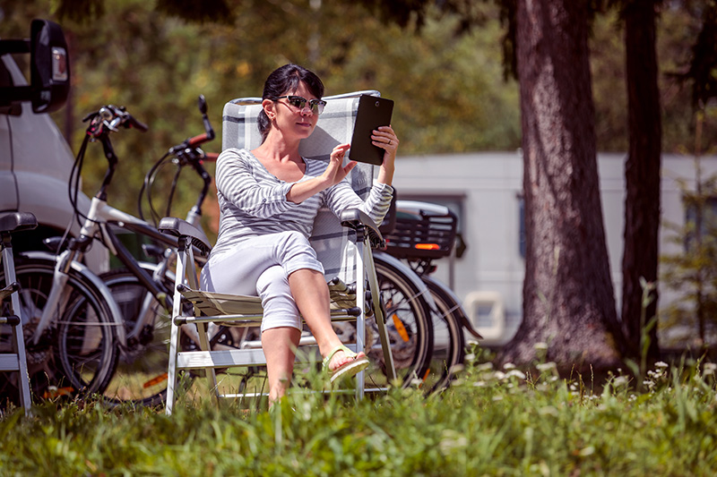 Woman using a tablet to schedule rv inspection